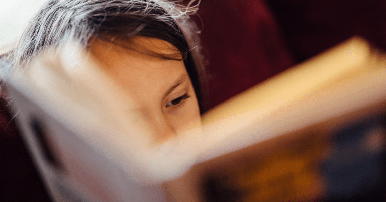 children reading a book close up